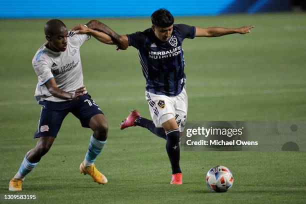 Lucas Maciel of New England Revolution and Adam Saldana of Los Angeles Galaxy battle for the ball during the first half at Dignity Health Sports Park...