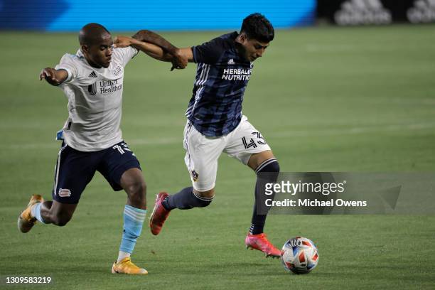Lucas Maciel of New England Revolution and Adam Saldana of Los Angeles Galaxy battle for the ball during the first half at Dignity Health Sports Park...