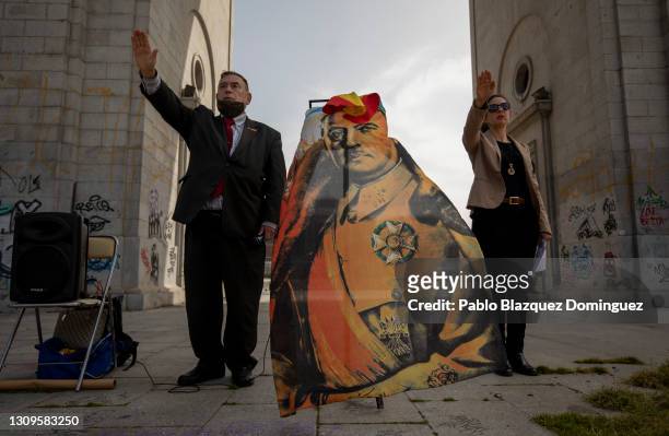 Franco supporters do the fascist salute as they display an image depicting Francisco Franco during a gathering of right-wing supporters at Arco de la...