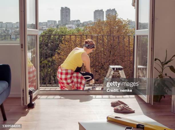woman painting the balcony fence - balcony stock pictures, royalty-free photos & images