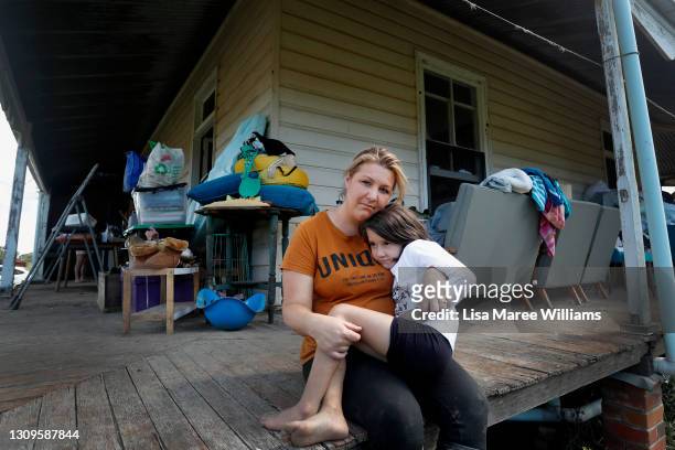 Em Trotter and daughter Evie-Meg sit on the verandah of their flood affected home in the small community of Croki on March 28, 2021 in Taree,...