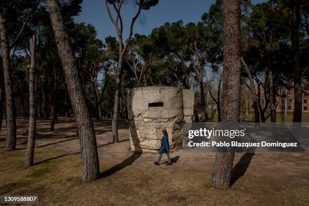 Woman walks past a machine gun pillbox that was used by Franco's forces to invade Madrid during the Spanish Civil War following the Spanish Coup of...