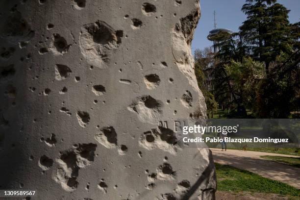 Man walks past a monument of Doctor Ricardo y Galí with bullet holes from the Siege of Madrid at during the Spanish Civil War in Parque del Oeste on...
