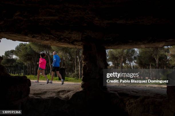 People running are seen through the hole of a machine gun pillbox that was used by Republicans to defend Madrid from Franco's forces during the...