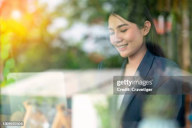 asian woman working on a laptop reflection with window light. - genius woman stock pictures, royalty-free photos & images