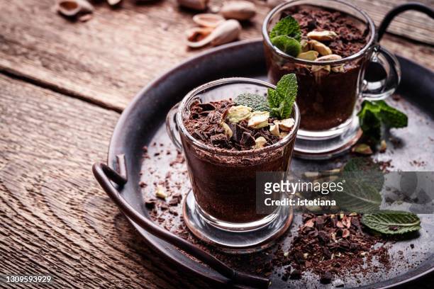 homemade dark chocolate mint mousse with pistachios in glasses - chocolate souffle stock-fotos und bilder
