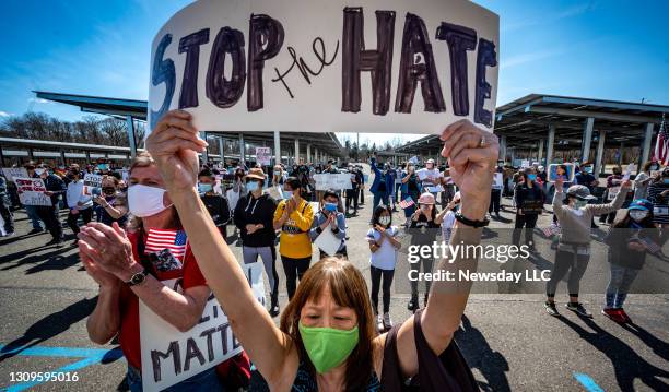 Long Island resident Patricia Shih holds a sign saying, "Stop the Hate," at the H. Lee Dennison Building in Hauppauge, New York during a rally to...