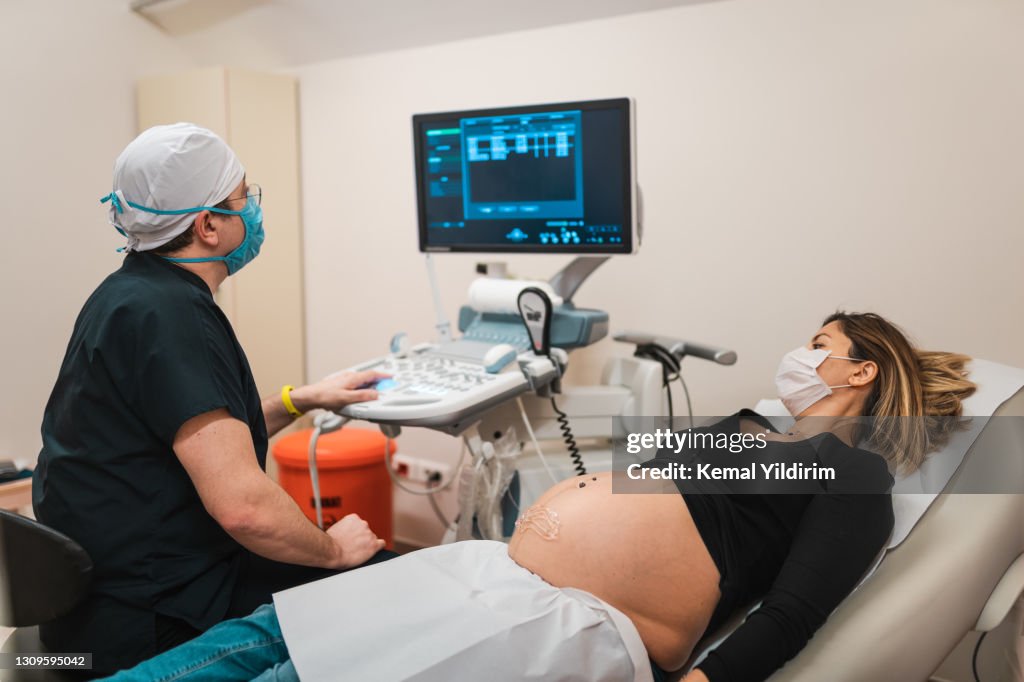 Pregnant woman watching her baby on the ultrasound