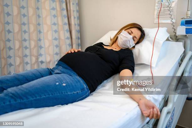 gravid kvinna vilar i sjukhussängen med iv - foster bildbanksfoton och bilder