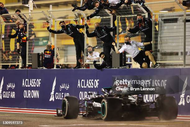 Mercedes GP team members celebrate on the pitwall as Lewis Hamilton of Great Britain driving the Mercedes AMG Petronas F1 Team Mercedes W12 crosses...