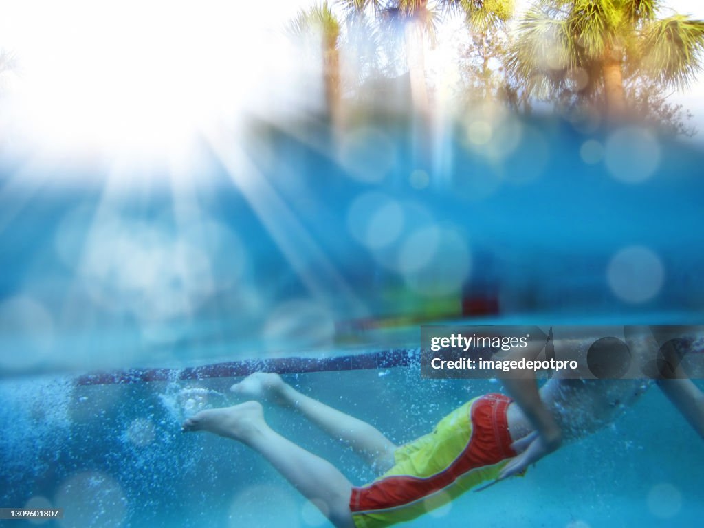 Underwater view of teenager boy swimming in swimming pool