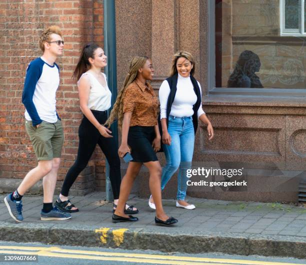 vrienden die samen op de straat lopen - west yorkshire stockfoto's en -beelden