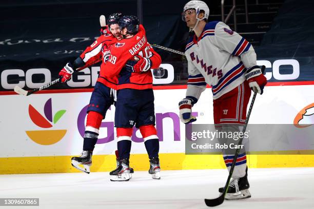 Tom Wilson of the Washington Capitals celebrates his second goal of the second period with teammate Nicklas Backstrom in front of Jacob Trouba of the...