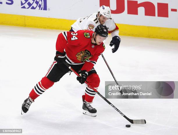 Carl Soderberg of the Chicago Blackhawks advances the puck past Jonathan Huberdeau of the Florida Panthers at the United Center on March 25, 2021 in...