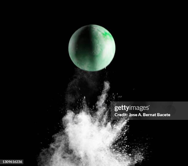 impact and rebound of a toy ball on a surface of land and powder on a black background - ballon rebond stock pictures, royalty-free photos & images