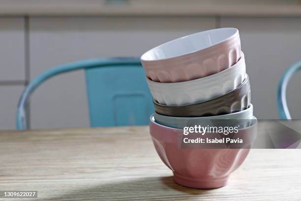 stack of colorful bowls on table - blue bowl stock-fotos und bilder