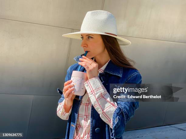 Julia Comil wears a white straw packable hat by Janessa Leone, a white and red shirt by Brock Collection, a blue denim jacket by Brock Collection,...