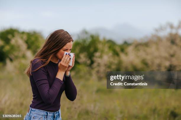 frau mit allergiesymptom blasen nase in der natur - allergie stock-fotos und bilder