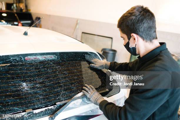 young technician preparing a car for the installation of a rear windshield - rear window stock pictures, royalty-free photos & images