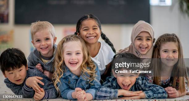 lächelnde und glückliche multiethnische vorschulkinder - montessori education stock-fotos und bilder