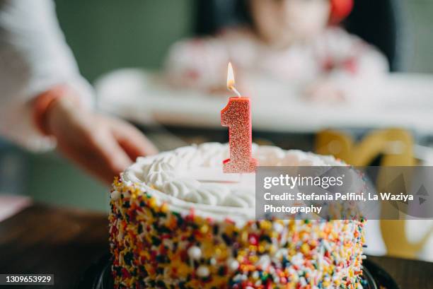 baby first birthday cake with lit candle - baby first birthday photos et images de collection