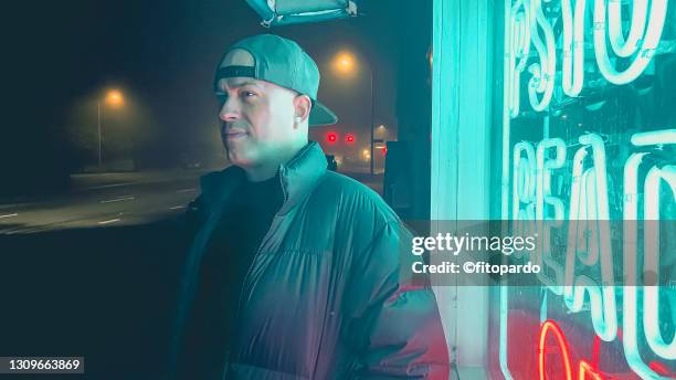 a man looks at the side during the night fog around town - hot latin nights stock pictures, royalty-free photos & images