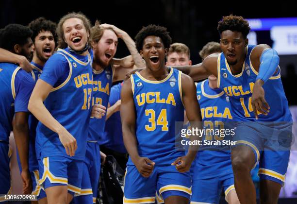 David Singleton of the UCLA Bruins celebrates with Kenneth Nwuba and Mac Etienne after defeating the Alabama Crimson Tide 88-78 in overtime in the...