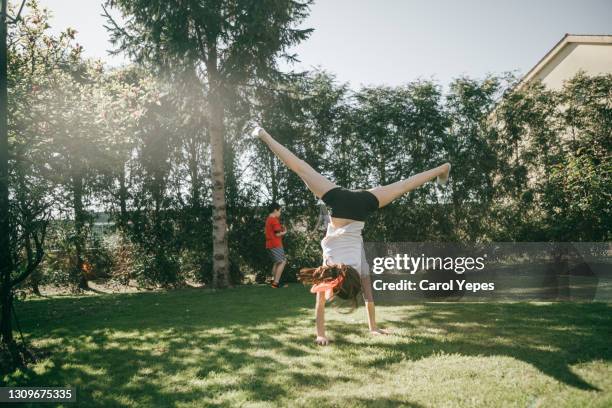 girl (10) performing cartwheel in backyard - cartwheel stock pictures, royalty-free photos & images