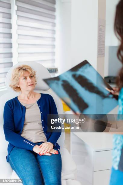 vrouwelijke geduldige zitting in het bureau van de arts, die op röntgenlezing wacht - chronic obstructive pulmonary disease stockfoto's en -beelden