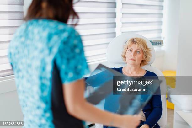 vrouwelijke geduldige zitting in het bureau van de arts, die voor röntgenresultaat wordt gezocht - chronic obstructive pulmonary disease stockfoto's en -beelden