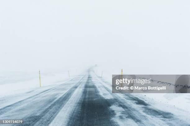 mountain icy road during snowfall - ventisca fotografías e imágenes de stock