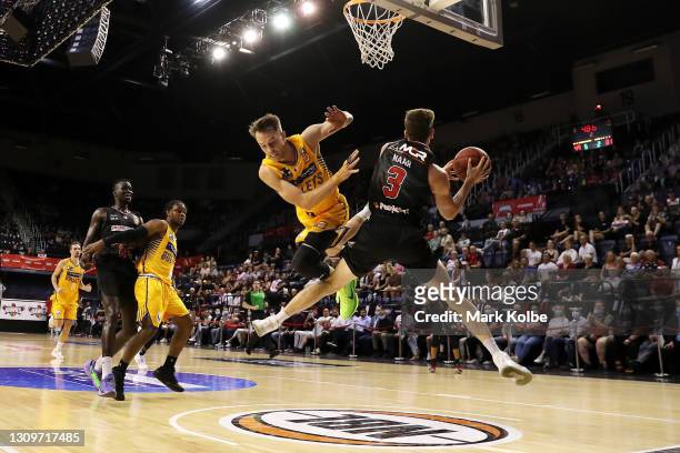 Emmett Naar of the Hawks is fouled by Nathan Sobey of the Bullets as he drives the ball to the basket during the round 11 NBL match between the...