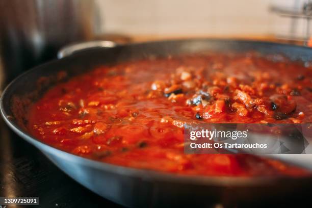 close up of tomato and vegetables sauce in a pan on the kitchen - close up cooking stock-fotos und bilder