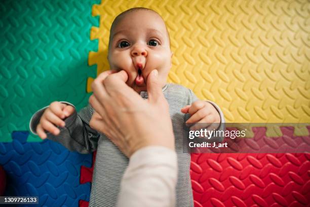 pinch the little baby's cheeks. - pressure photos et images de collection