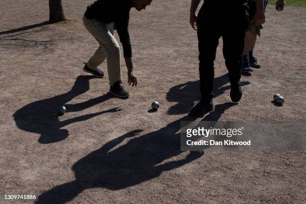 Members of a Petanque club play in Vauxhall pleasure gardens on March 29, 2021 in London, United Kingdom. Today the government eased its rules...