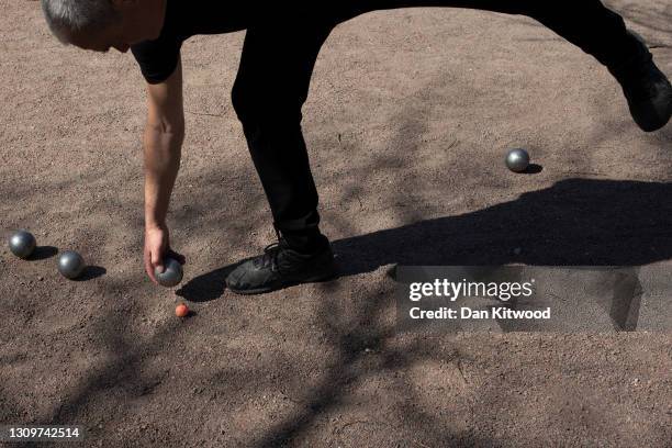 Members of a Petanque club play in Vauxhall pleasure gardens on March 29, 2021 in London, United Kingdom. Today the government eased its rules...