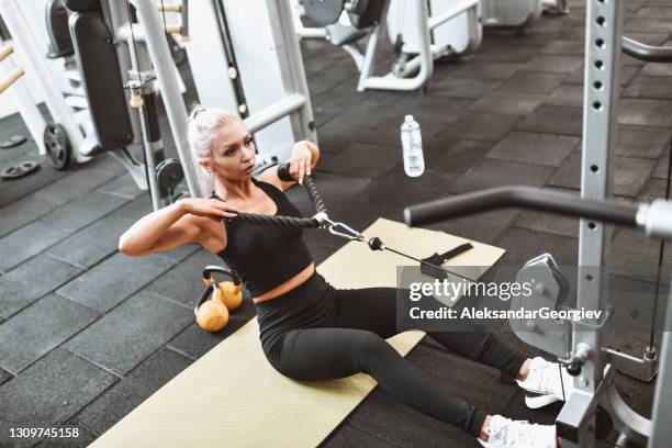 blonde female athlete practicing row exercise in gym - weight stock pictures, royalty-free photos & images