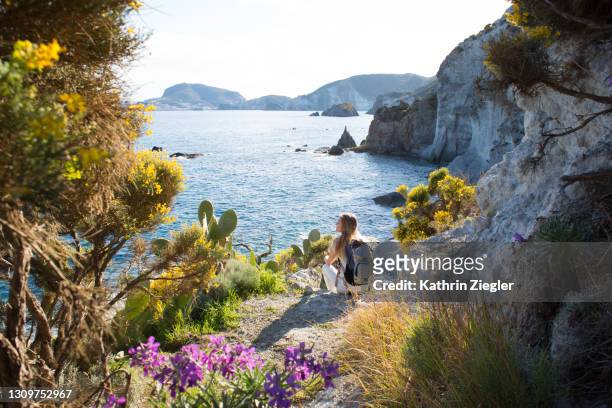 woman resting on coastal footpath, looking at the sea - mer tyrrhénienne photos et images de collection