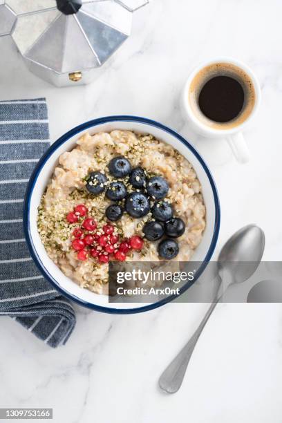 oatmeal porridge with berries and cup of coffee - porridge stock pictures, royalty-free photos & images