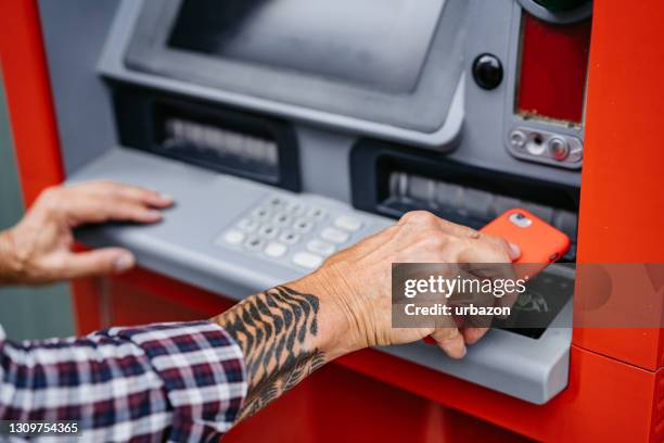 hombre retirando dinero con billetera digital - pago-sin-contacto fotografías e imágenes de stock