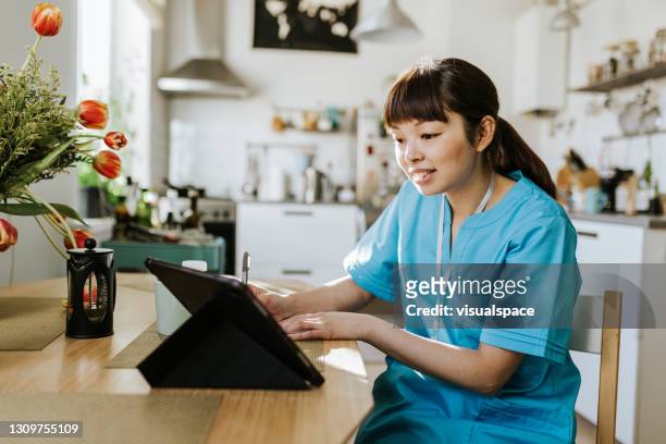 de arbeider van de gezondheidszorg op videogesprek met een patiënt - vitale beroepen stockfoto's en -beelden