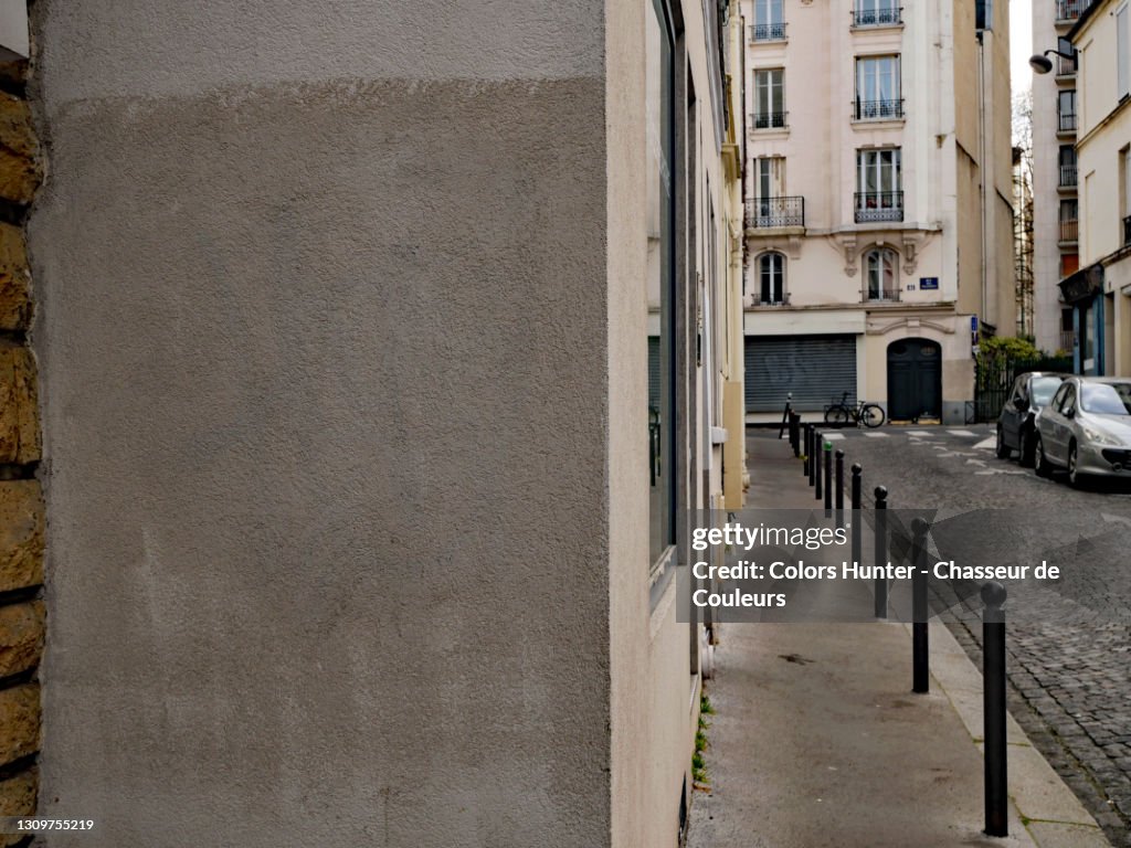 Gray concrete wall and cobbled street in Paris with no people