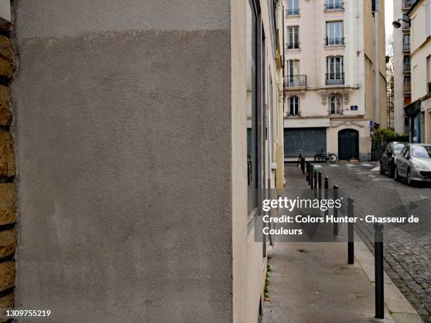 gray concrete wall and cobbled street in paris with no people - corners stock-fotos und bilder