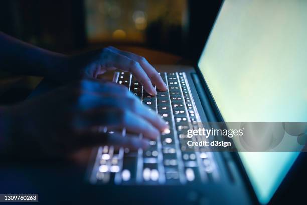 close up of woman's hand typing on computer keyboard in the dark, working late on laptop at home - アクセス ストックフォトと画像