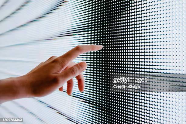 close up of woman's hand touching illuminated led display screen, connecting to the future - touching imagens e fotografias de stock