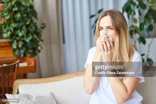 woman blowing nose. a virus. the disease. the first signs of the disease. stay at home. treatment - sinus stock-fotos und bilder