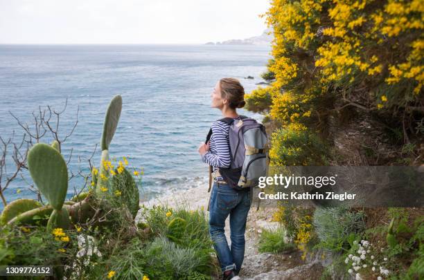 woman hiking on coastal footpath, looking at the sea - wonderlust imagens e fotografias de stock