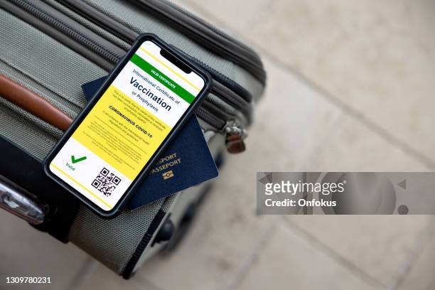 digitale impfstoff-pass-app im handy für reisen während der covid-19-pandemie - airport smartphone stock-fotos und bilder