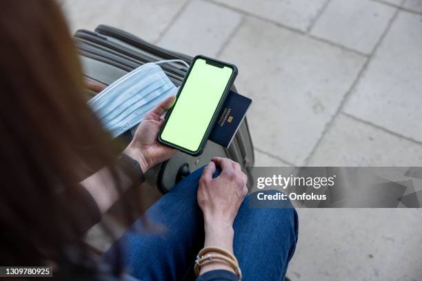 vaccinated woman using digital vaccine passport app in mobile phone for travel during covid-19 pandemic - canada passport stock pictures, royalty-free photos & images