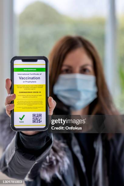 femme vaccinée utilisant l’application numérique de passeport de vaccin dans le téléphone portable aux douanes pour le voyage pendant la pandémie de covid-19 - passeport vaccinal photos et images de collection